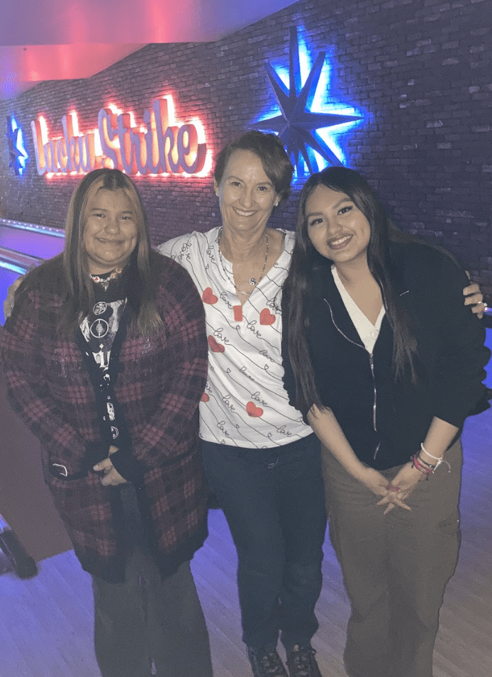 Two teens, woman, at bowling alley